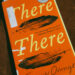 A close-up of a library copy of "There There" by Tommy Orange, with some light damage to the cover.